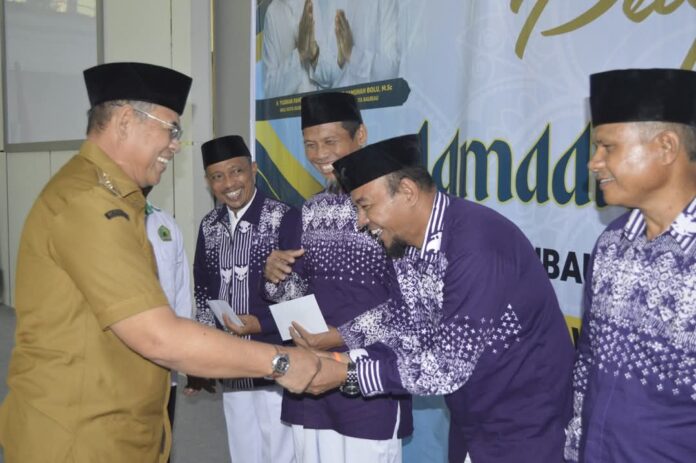 Wali Kota Baubau, H Yusran Fahim bersalaman dengan perwakilan 143 JCH Baubau di Aula Wali Kota Baubau, Senin (19/5/2025). (foto Kominfo Baubau)