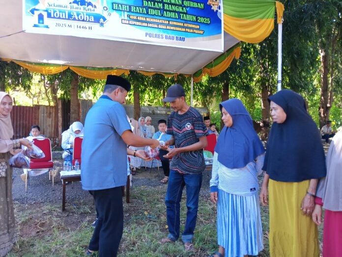 IMG-20250606-WA0000 Kapolres Baubau, AKBP Mayestika Hidayat (sebelah kiri) membagikan daging kurban kepada warga. (Dokumen Humas Polres Baubau)